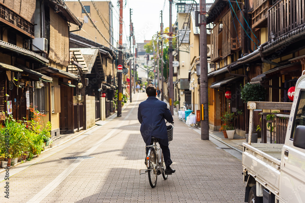 Naklejka premium Cyclist on a city street in Kyoto, Japan. Copy space for text.