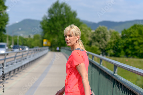 Blond woman crossing a pedestrian bridge