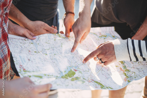 Traveling, sightseeing, group travel, city tour, student exchange program, vacation, holiday. Friends searching the location on map, planing journey