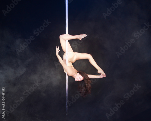 Pole Dancer performing a mix of the poses cocoon and brass monkey