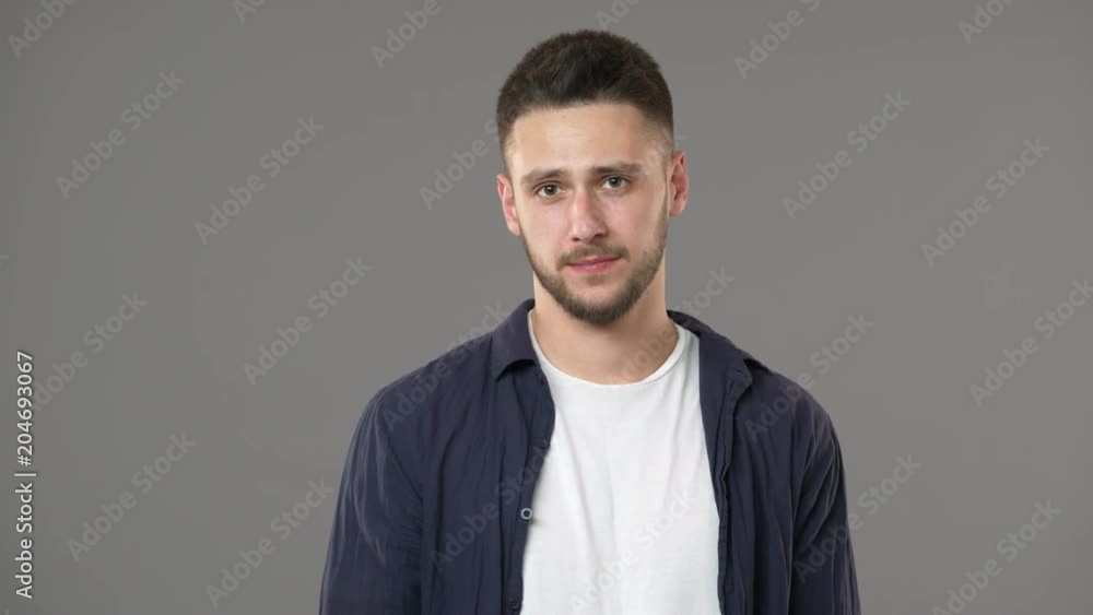 Portrait of puzzled man in casual clothing having complicated conversation and shaking head in rejection, isolated over gray background. Concept of emotions Portrait of puzzled man in casual clothing having complicated conversation and shaking head in rejection, isolated over gray background. Concept of emotions