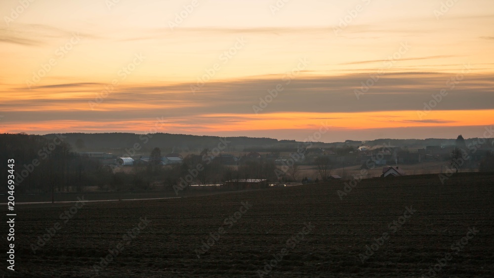 Late evening sky over village near fields