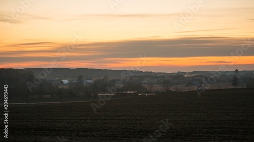 Late evening sky over village near fields