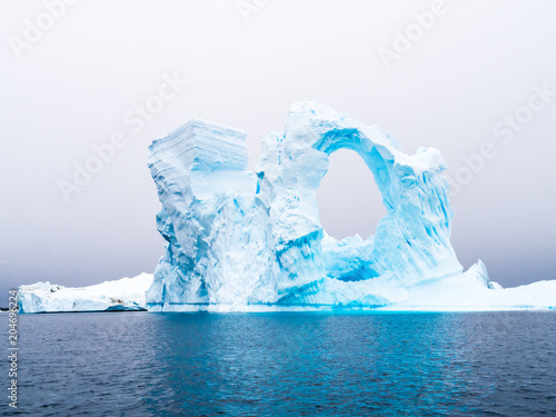 Arch shaped iceberg in Pleneau Bay iceberg graveyard west of Antarctic Peninsula, Antarctica