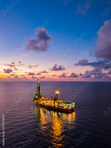 Aerial View of Tender Drilling Oil Rig (Barge Oil Rig) in The Middle of The Ocean at Sunset Time © bomboman