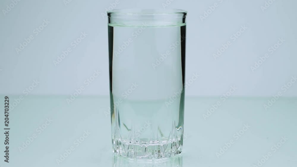 An effervescent pill dissolves slow-motion shot of aspirin on a colored background An effervescent pill dissolves slow-motion shot of aspirin on a colored background