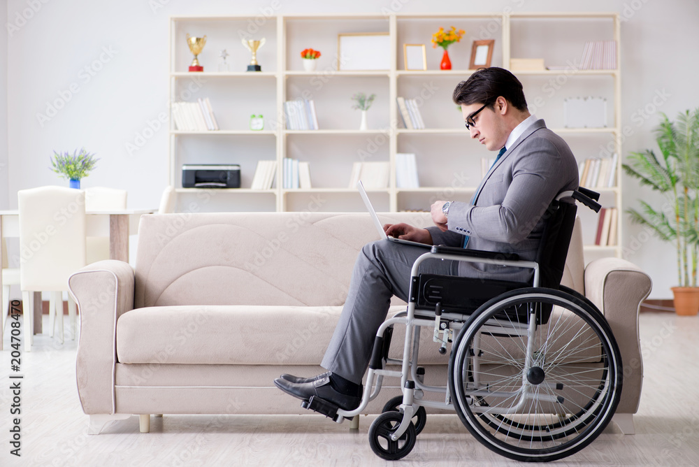 Dsabled businessman on wheelchair working home Dsabled businessman on wheelchair working home