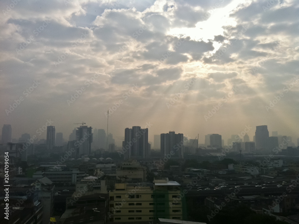 Cloudy polluted city with sun beam light