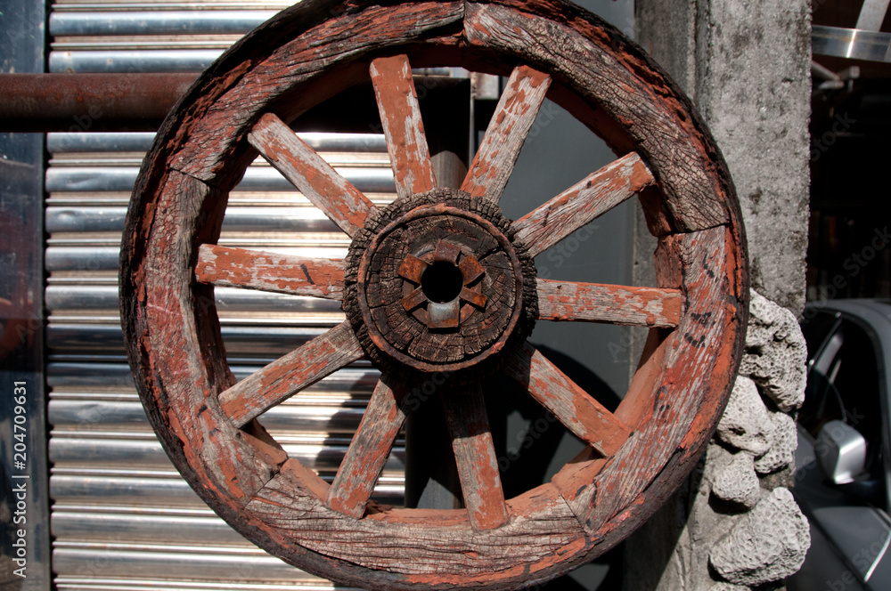 Wooden old carriage wheel in a farm