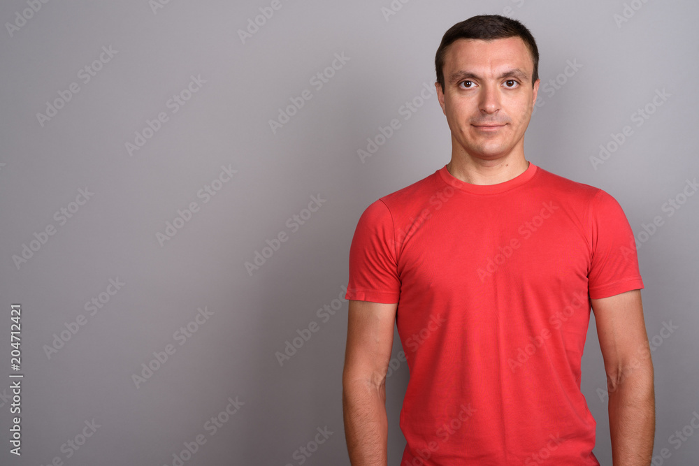 Man wearing red shirt against gray background Man wearing red shirt against gray background