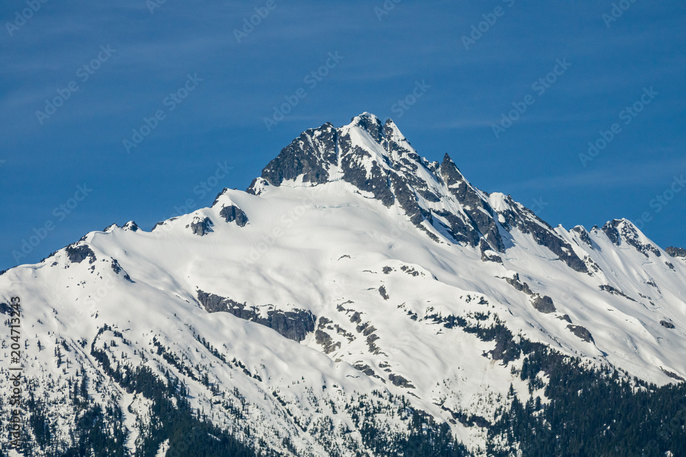 majestic mountain peak covered with snow under the blue sky in a sunny day