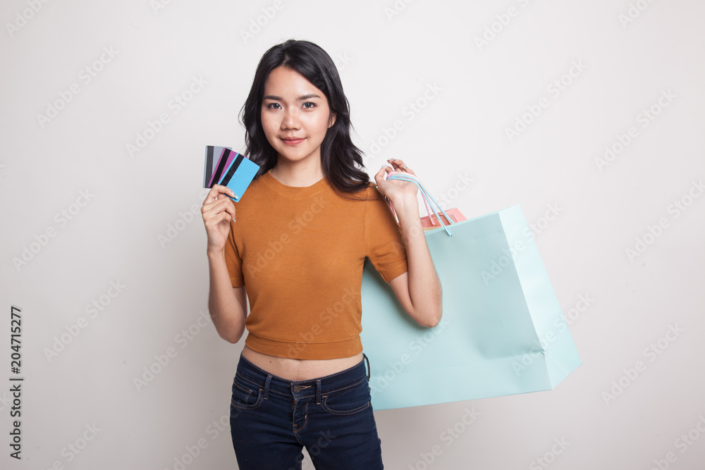 Young Asian woman with shopping bag and blank card. Young Asian woman with shopping bag and blank card.