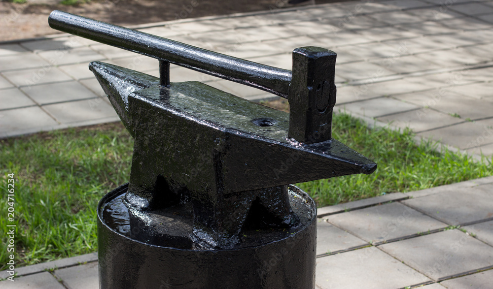 An anvil and a large hammer of the church color An anvil and a large hammer of the church color