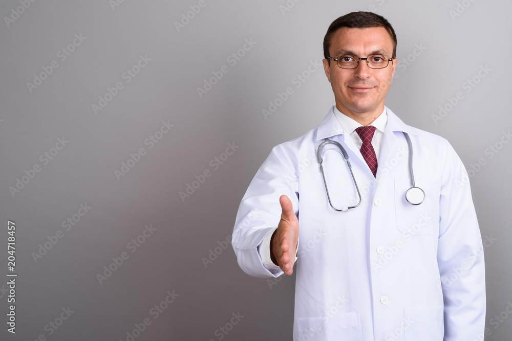 Man doctor wearing eyeglasses against gray background Man doctor wearing eyeglasses against gray background