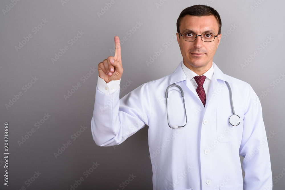 Man doctor wearing eyeglasses against gray background Man doctor wearing eyeglasses against gray background
