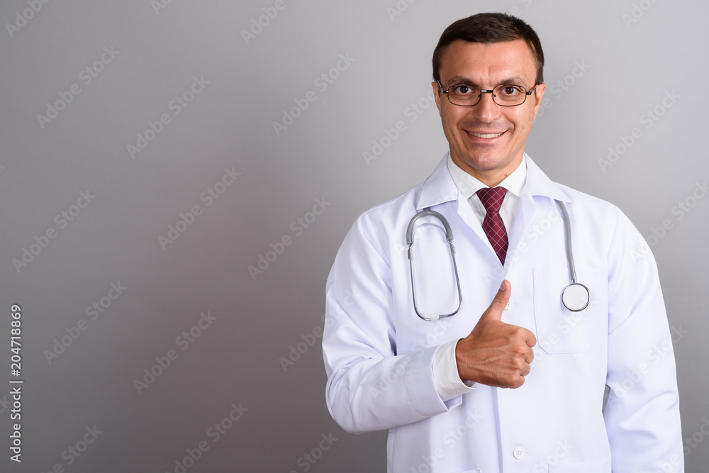 Man doctor wearing eyeglasses against gray background Man doctor wearing eyeglasses against gray background