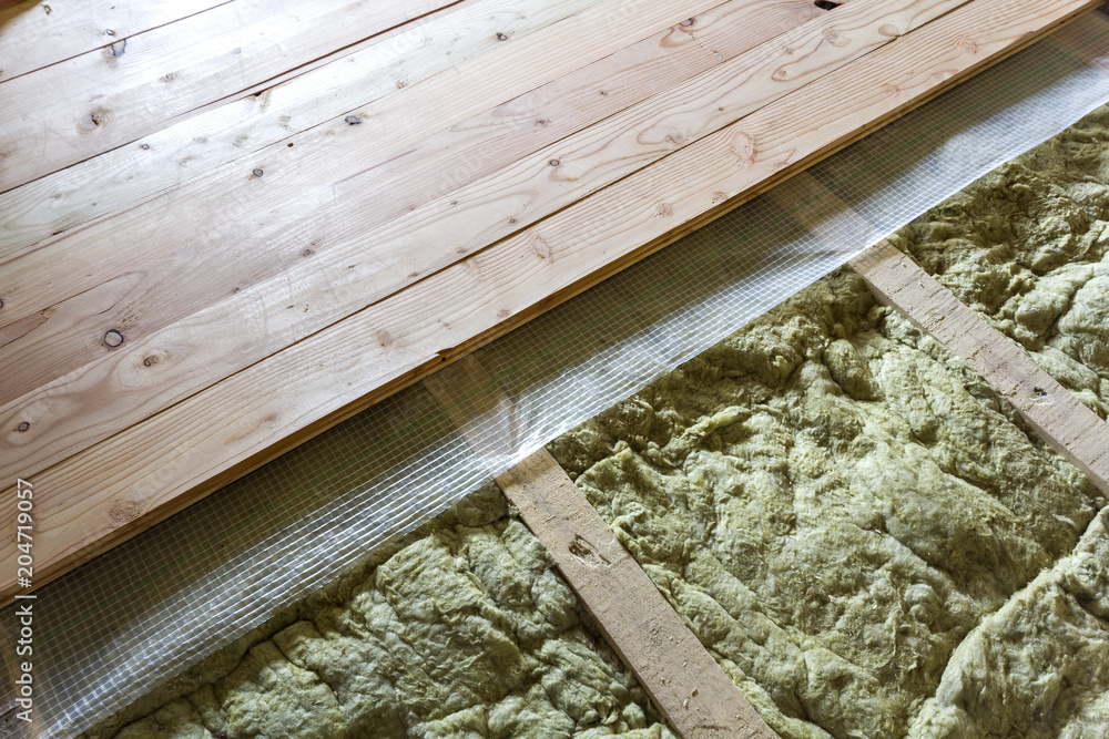 Installation of new floor of wooden natural planks and mineral wool insulation for isolation and keeping warmth. Construction, renovation, warm comfortable house concept. - obrazy, fototapety, plakaty 