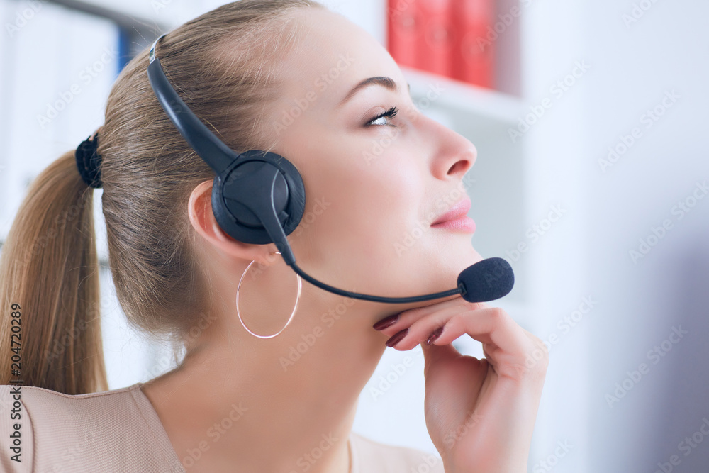 Close-up portrait of a customer service agent sitting at office propped her head by hand and dreaming. Close-up portrait of a customer service agent sitting at office propped her head by hand and dreaming.