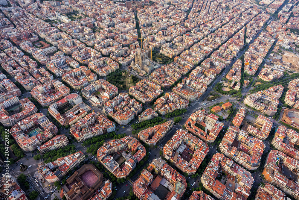Fototapeta premium Widok z lotu ptaka Barcelony, dzielnica mieszkaniowa Eixample z typową siatką miejską, Hiszpania. Światło późnego popołudnia