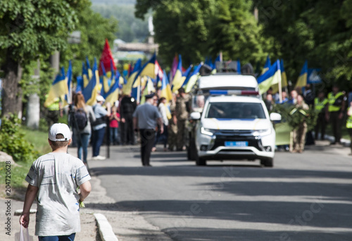 мальчик идущий на встречу демонстрации с флагами и милицией