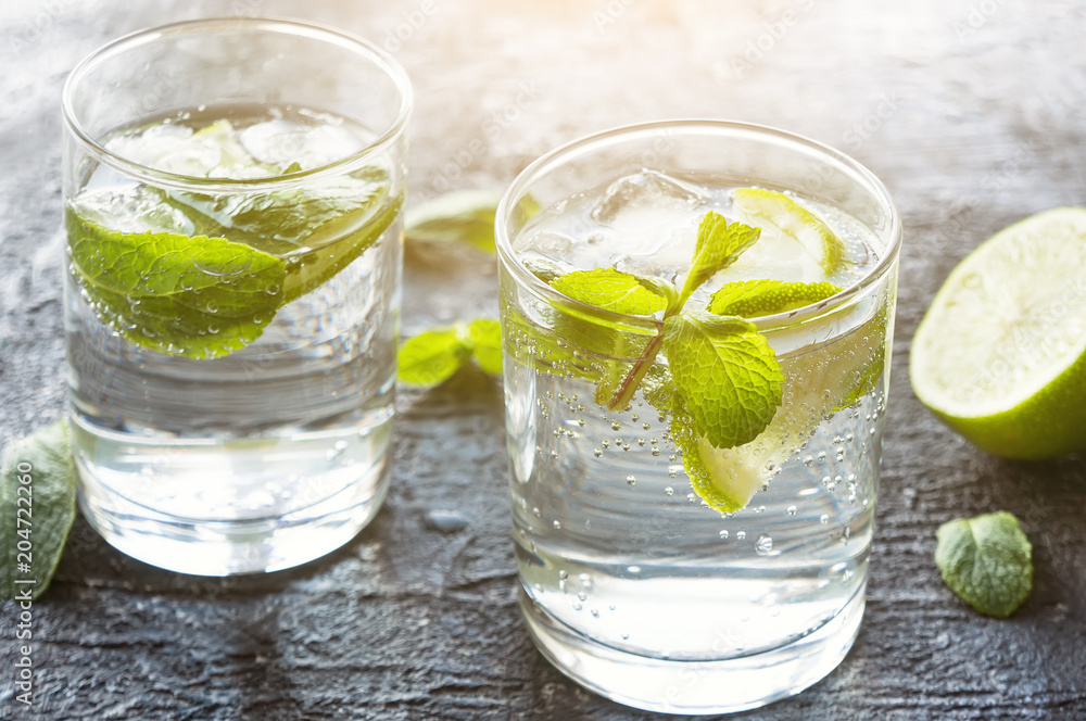 Mojito cocktail. Iced drink with lime and mint. Dark stone background. Mojito cocktail. Iced drink with lime and mint. Dark stone background.