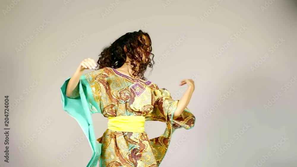 pretty african woman is leaping and whirling, dancing traditional folk dance, standing alone in studio pretty african woman is leaping and whirling, dancing traditional folk dance, standing alone in studio