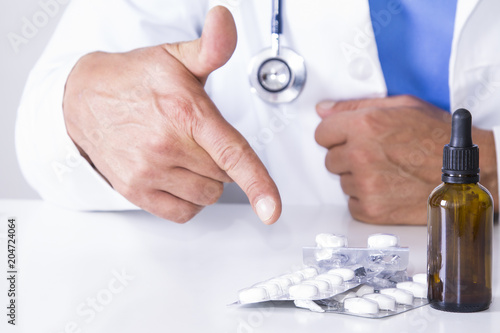 doctor with medication and pills at the hospital table