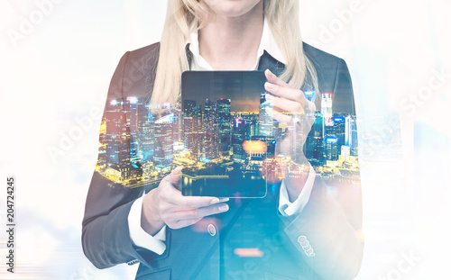 Businesswoman with a tablet computer, night city