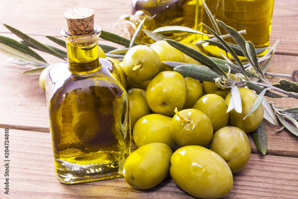 olives and bottle of extra virgin olive oil on wood olives and bottle of extra virgin olive oil on wood
