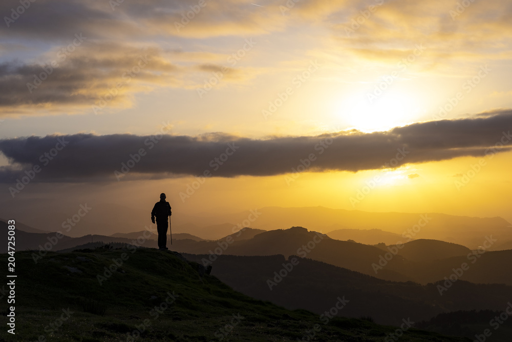 Man celebrating success on top of a mountain in sunrise. Man celebrating success on top of a mountain in sunrise.