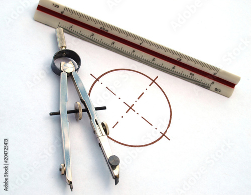 vintage drawing tools: compass and scale meter, over a white paper with a circumference photo