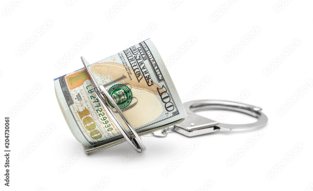 Rolled up dollar bills with handcuffs on white. Rolled up dollar bills with handcuffs on white.