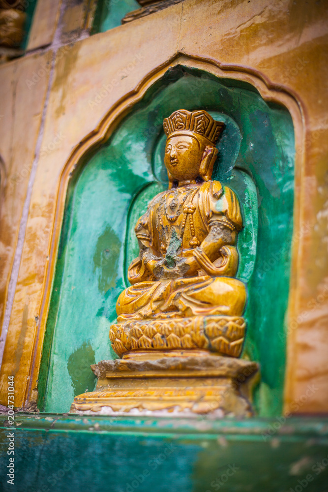 Decorative Wall of Rows of Small Buddha Figurines Sitting in Alcoves (Beijing, China).