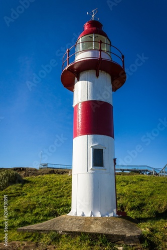 Red and white lighthouse on Niebla Fort on sunny day in South Chile
