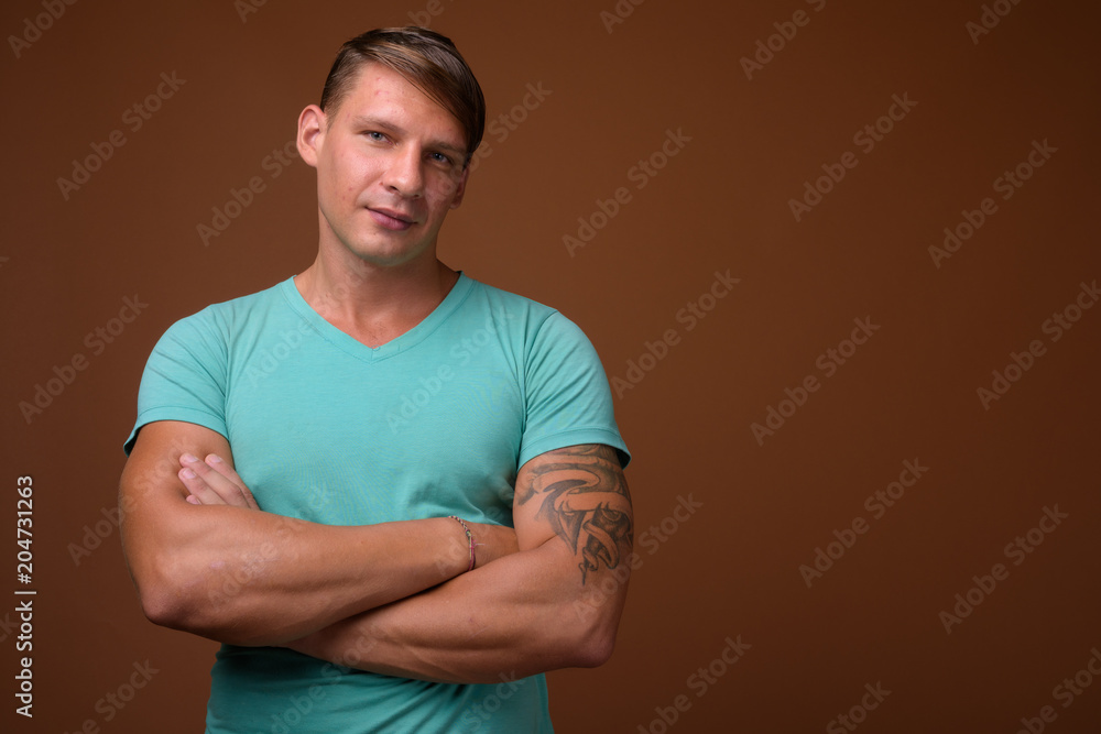 Studio shot of muscular man against brown background