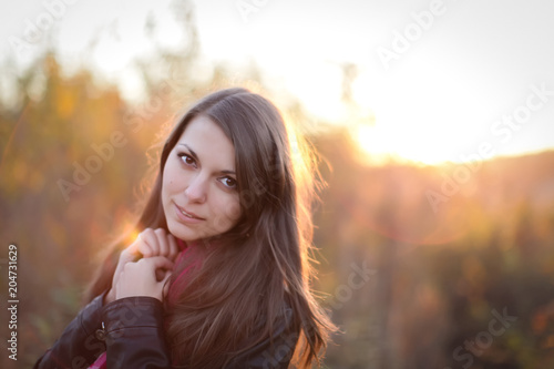 close Portrait of Beautiful girl at sunset in a field with blurry background