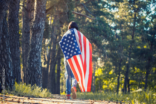 happy smiling young woman with national american flag outdoors