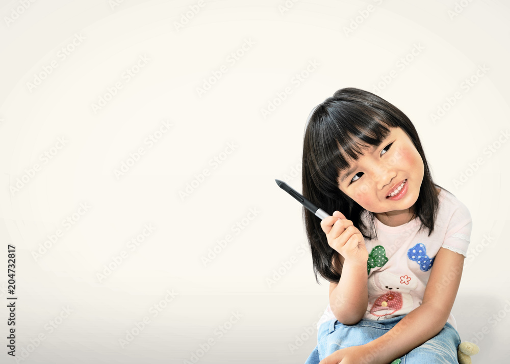 little asian girl handle the pen and thinking acting on light yellow background with clipping path little asian girl handle the pen and thinking acting on light yellow background with clipping path