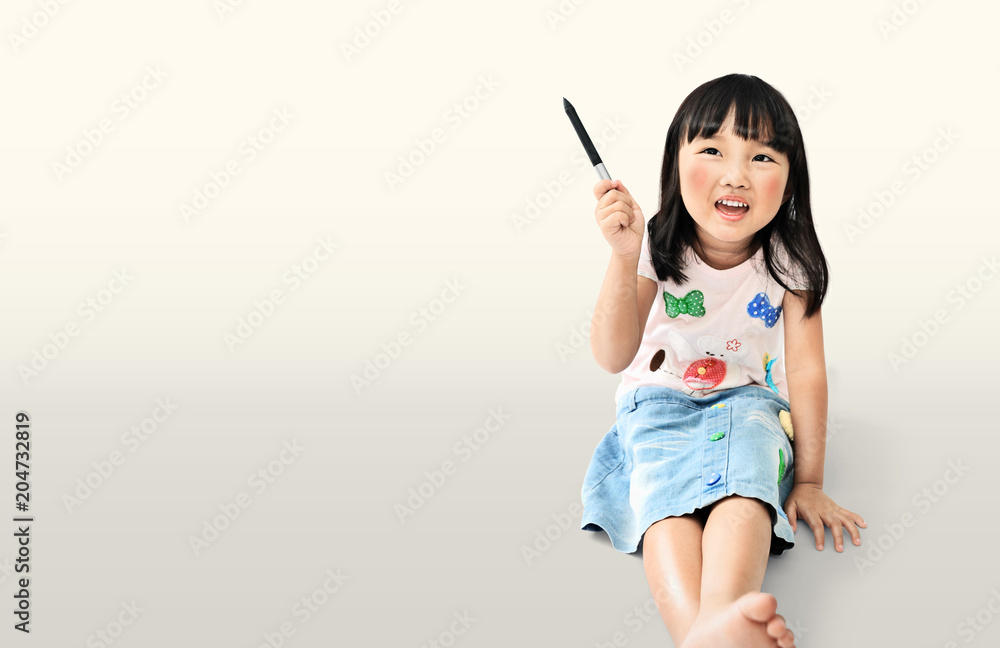 little asian girl smiling handle the pen and thinking acting on light yellow background with clipping path little asian girl smiling handle the pen and thinking acting on light yellow background with clipping path