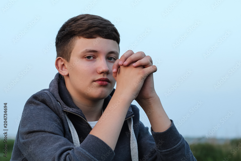 sad lonely teenager in the background of nature. serious look sad lonely teenager in the background of nature. serious look