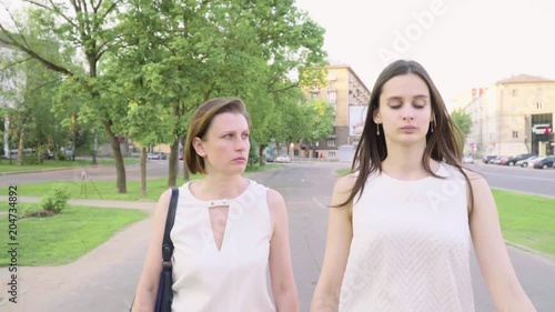 Mother and adult daughter swear and chatting in the park on a sunny day photo