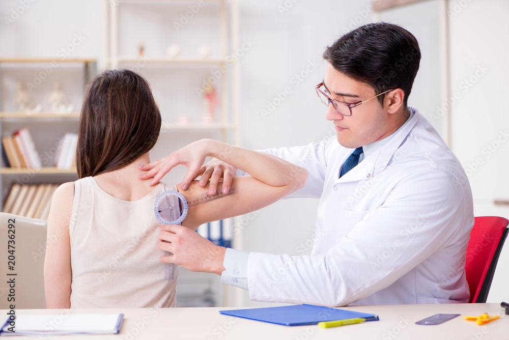Fototapeta premium Doctor checking patients joint flexibility with gonimeter