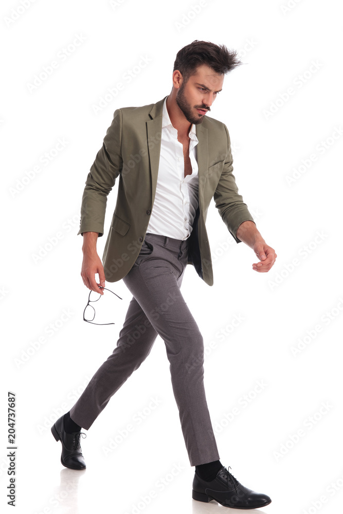 attractive man with green suit walking to side attractive man with green suit walking to side