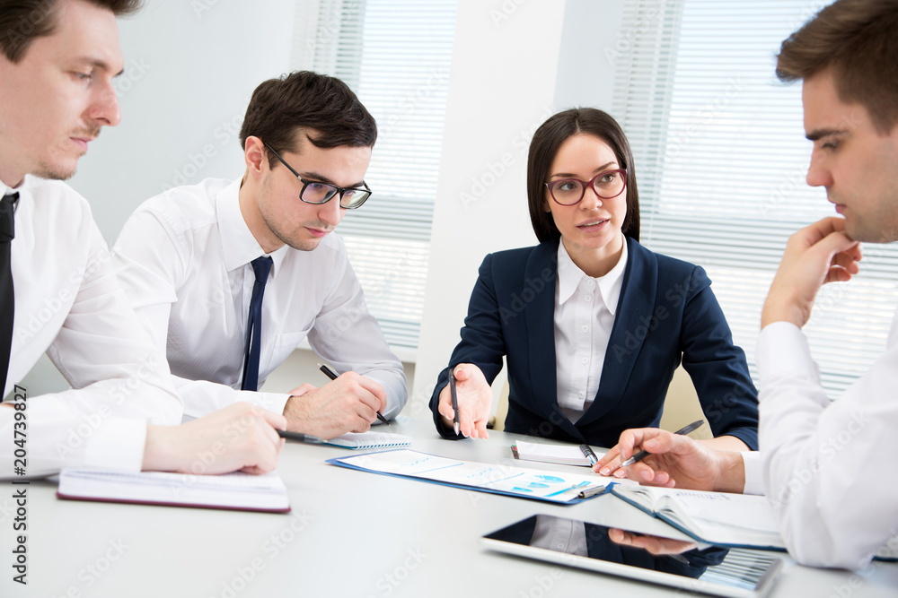 Businesswoman explains to businessmen a new project Businesswoman explains to businessmen a new project