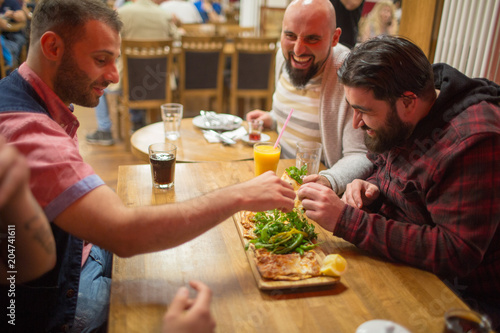 Men in restaurant eating Turkish Lahmacun  Armenian pizza. Selective focus