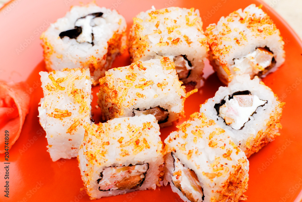 Bright sushi rolls on an orange plate. Japanese food. Bright sushi rolls on an orange plate. Japanese food.