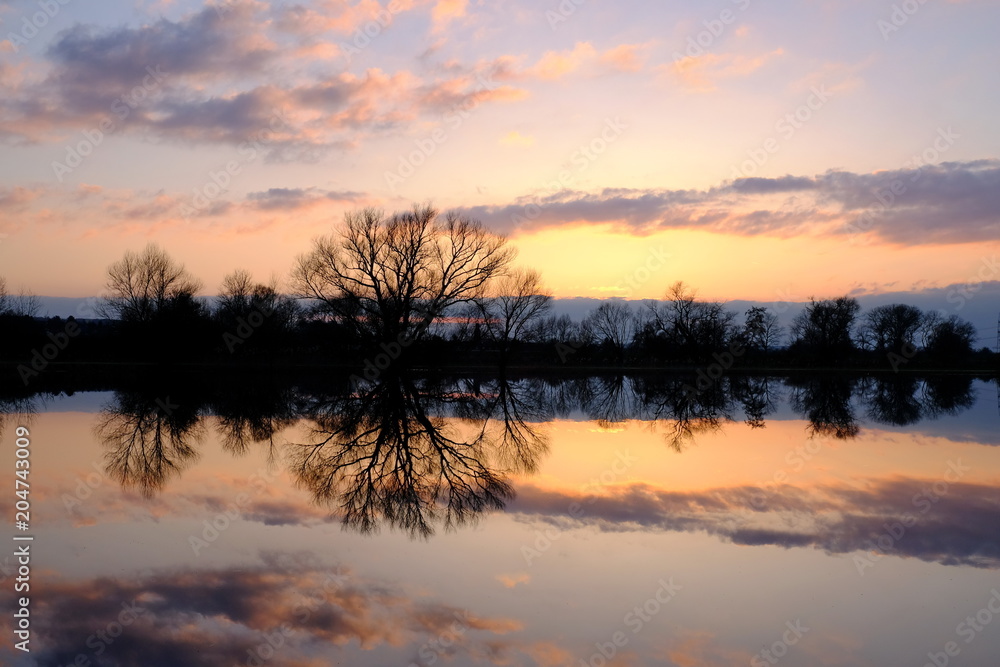 Fototapeta premium Sonnenuntergang mit Spiegelung auf dem Wasser