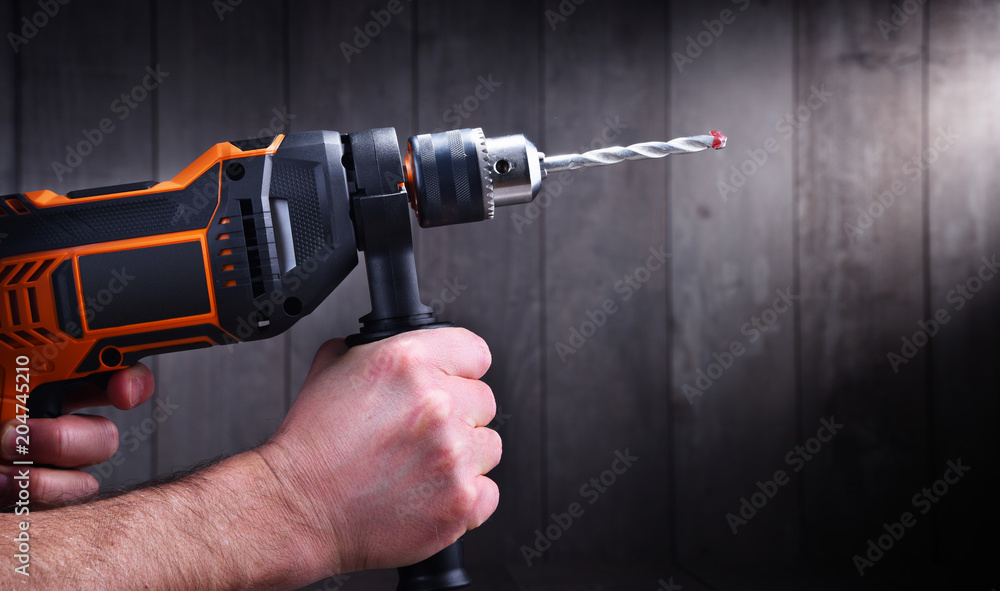Male hands holding power drill Male hands holding power drill