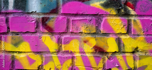 Fragment of colorful graffiti drawing made with aerosol paints on a brick wall