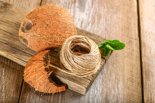 Foto Rope of fiber coir and coconut shell on an old wooden table.